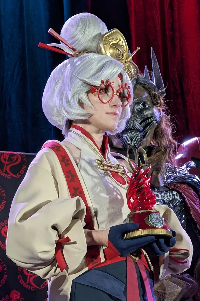 Rose City Comic Con 2025 Best in Show winner @pikminlink on stage in costume holding the red Hoku Props trophy