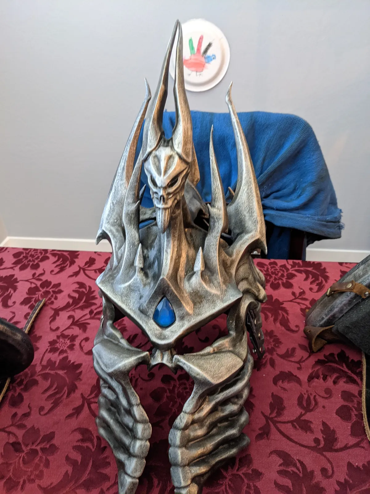 Front view of the Lich King helmet by Hoku Props with a blue gem and swept crown spikes