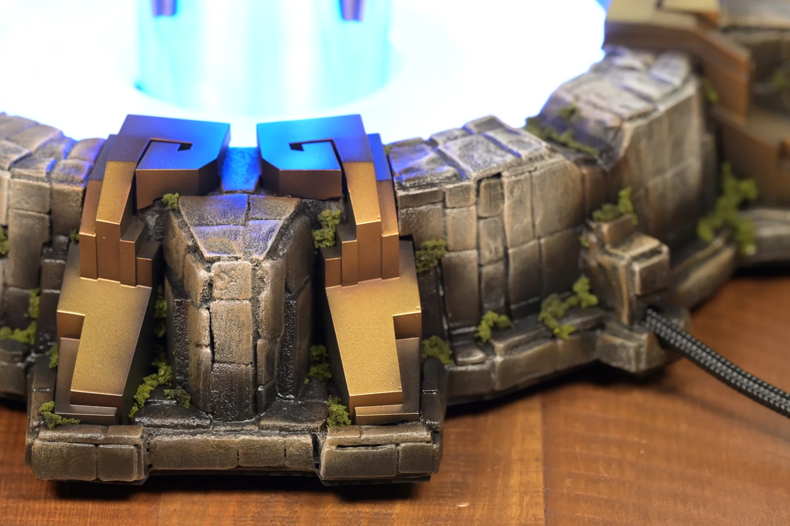 Close detail of the Champions Queue trophy base by Hoku Props, hand-painted stone with moss and gold column clamps