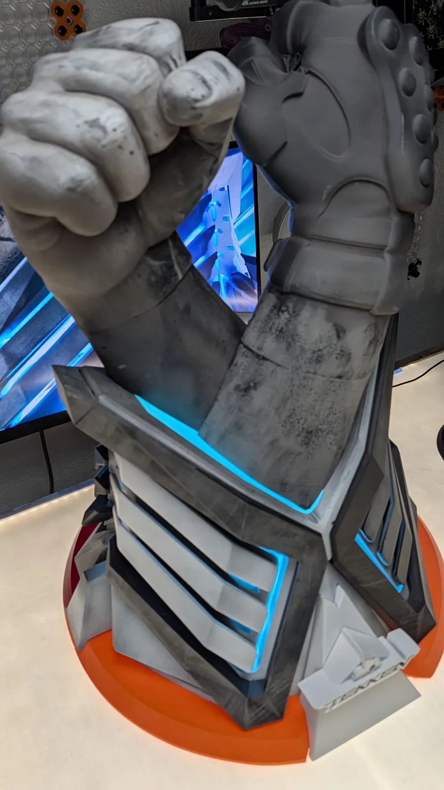 Close view of the lit TEKKEN World Tour 2025 trophy during testing, fists above glowing chevrons