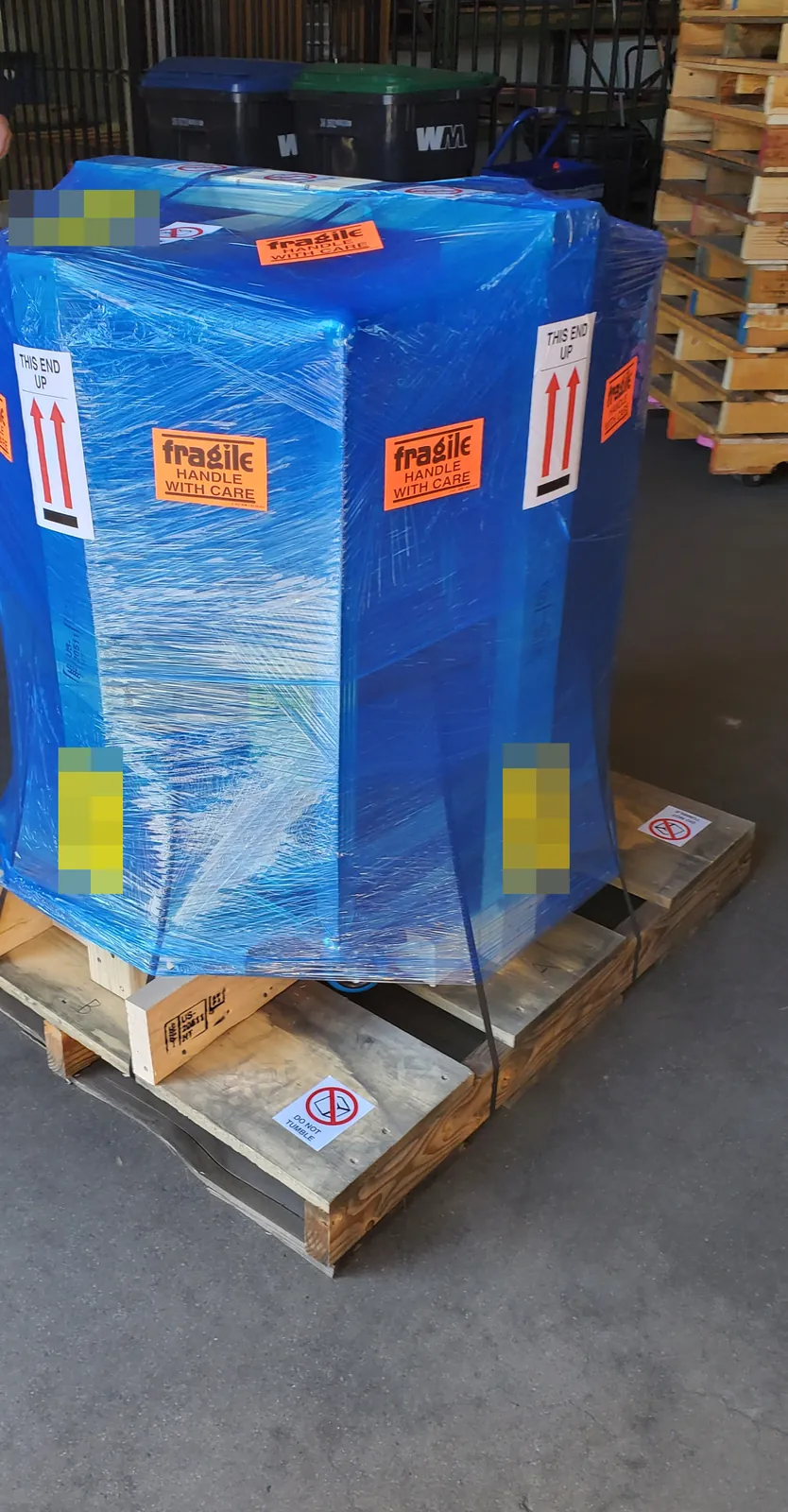 The crated trophy wrapped in blue plastic on its pallet, ready for freight