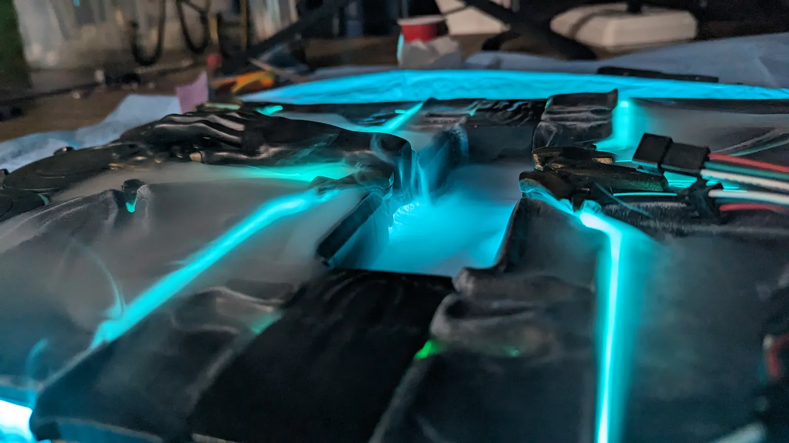 Teal LED light channels inside the cover of the Hoku Props Albrecht's Grimoire during the build