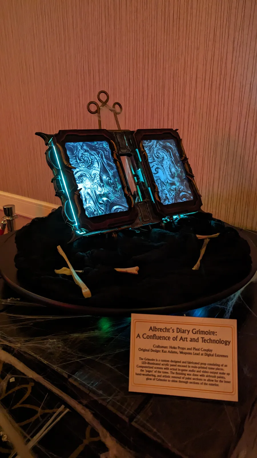 Albrecht's Grimoire by Hoku Props on display at TennoVIP 2023 in Las Vegas with its placard
