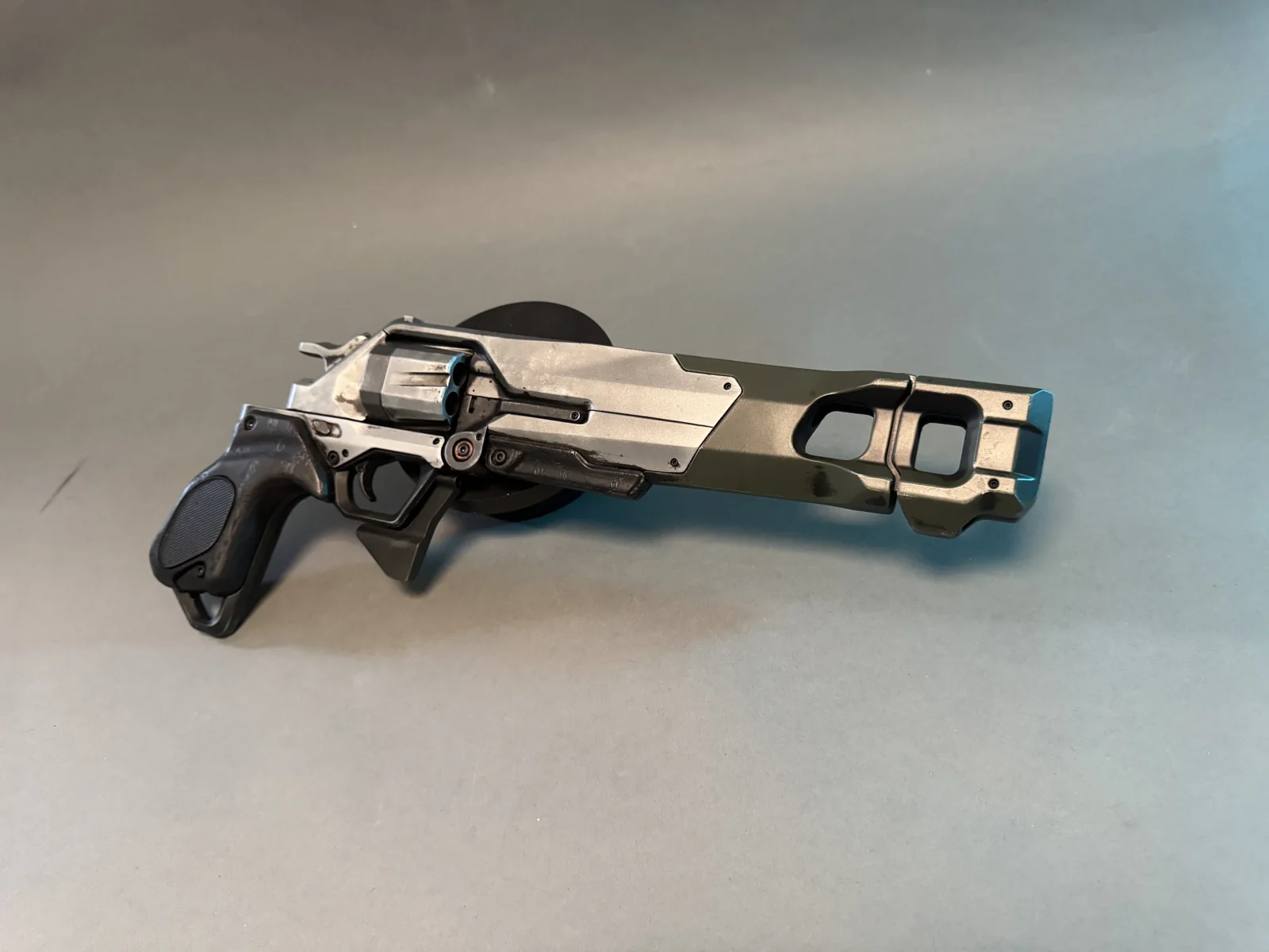 Highguard Longhorn revolver replica by Hoku Props in brushed metal and olive green, on a grey studio backdrop
