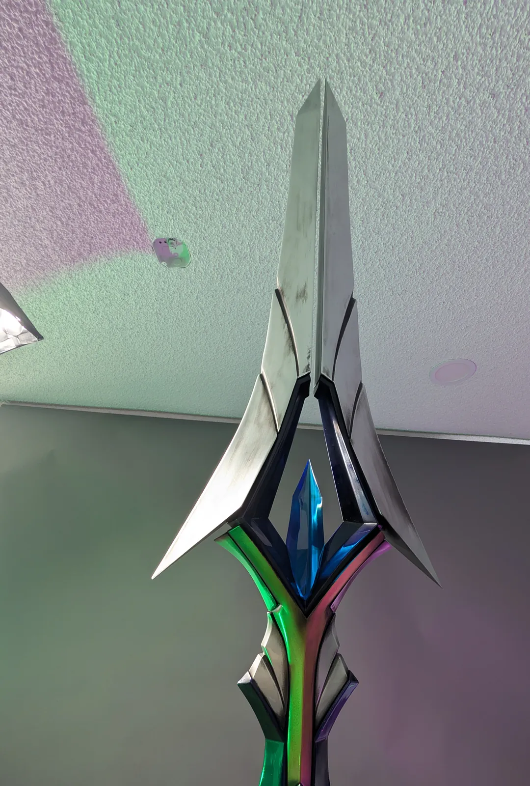 Close view of the finished spear head showing color-shift paint and weathering